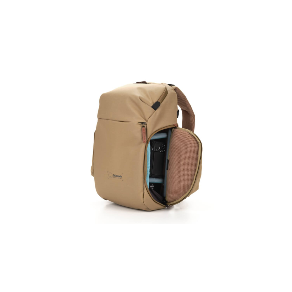 A tan camera backpack with an open compartment revealing a camera.