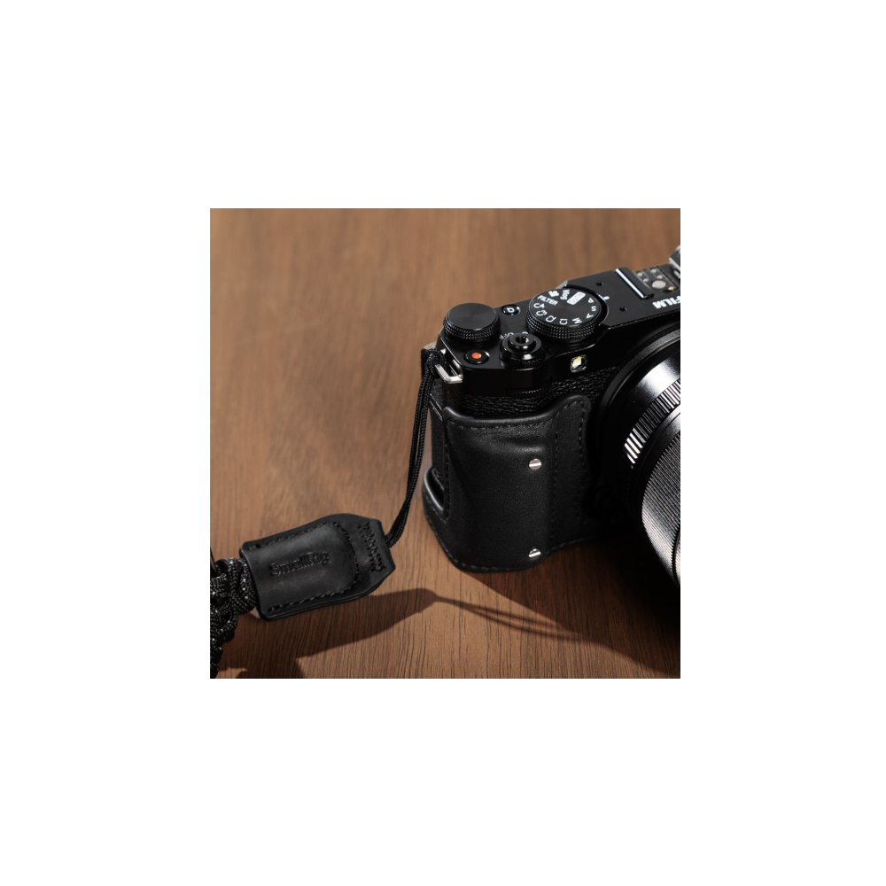 Close-up of a black leather case on a camera with a camera strap.