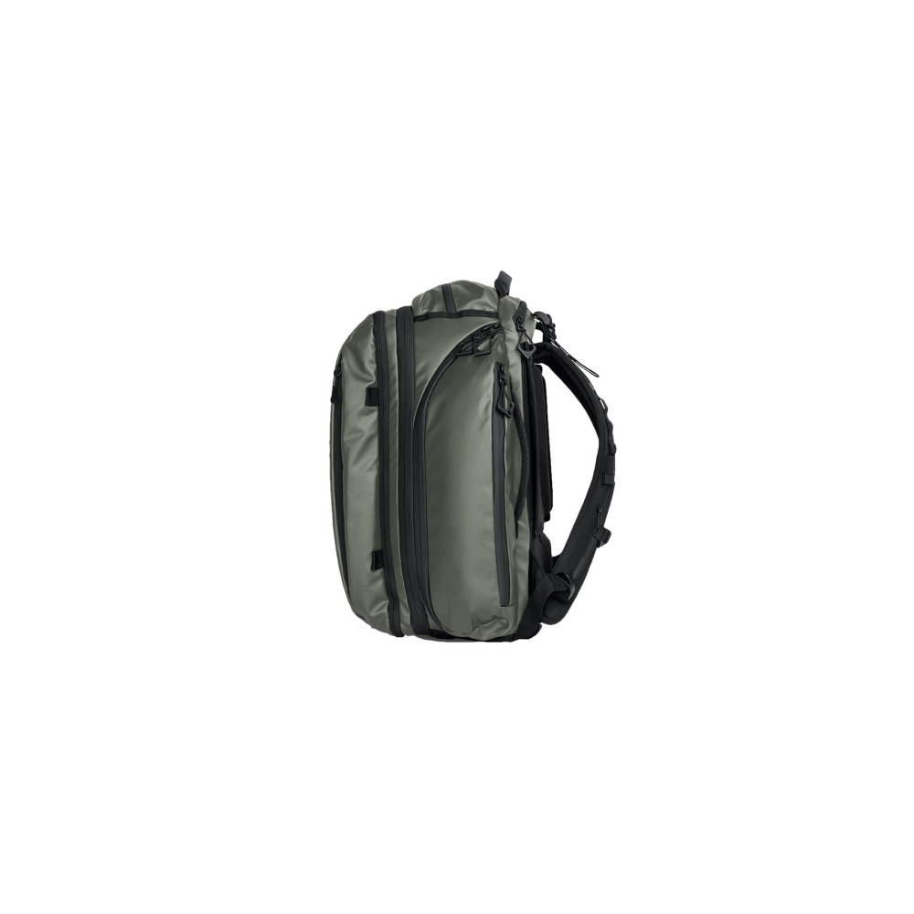 An olive green backpack with black zippers and straps, seen from the side.
