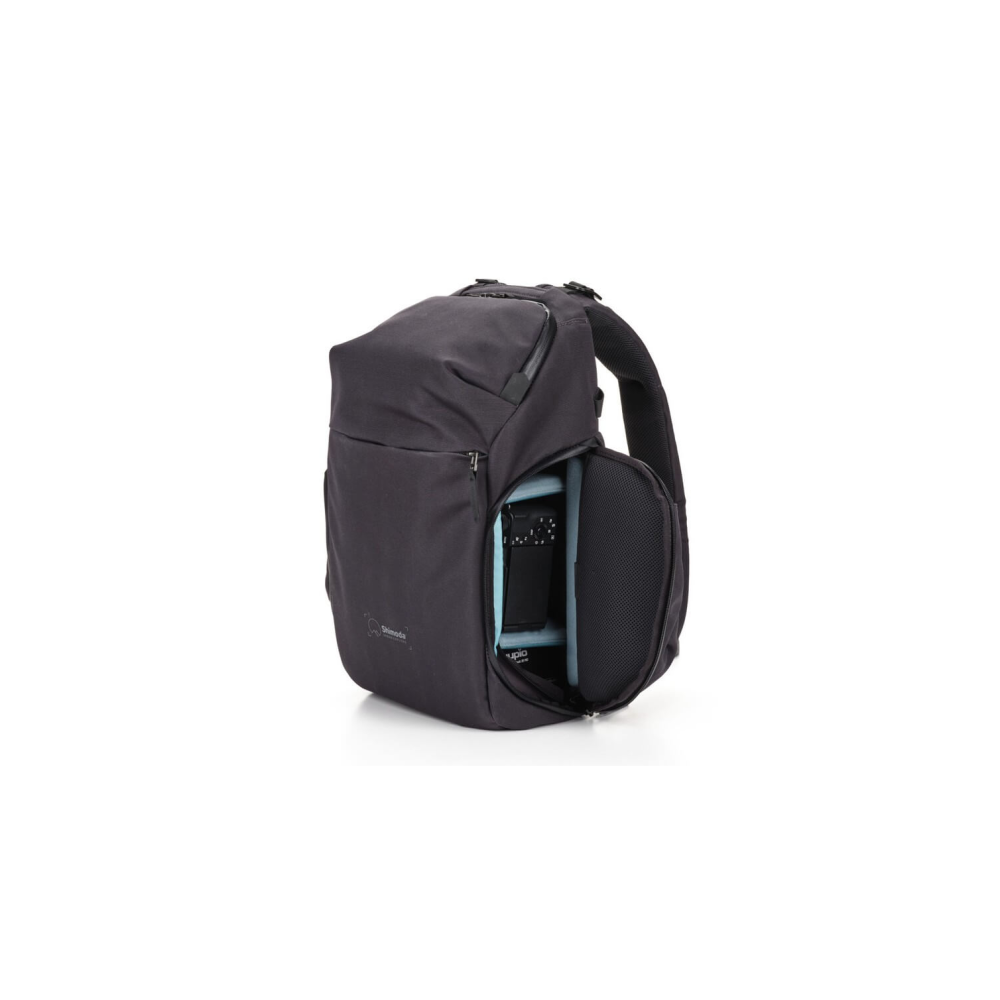A dark backpack with an open compartment revealing a camera.