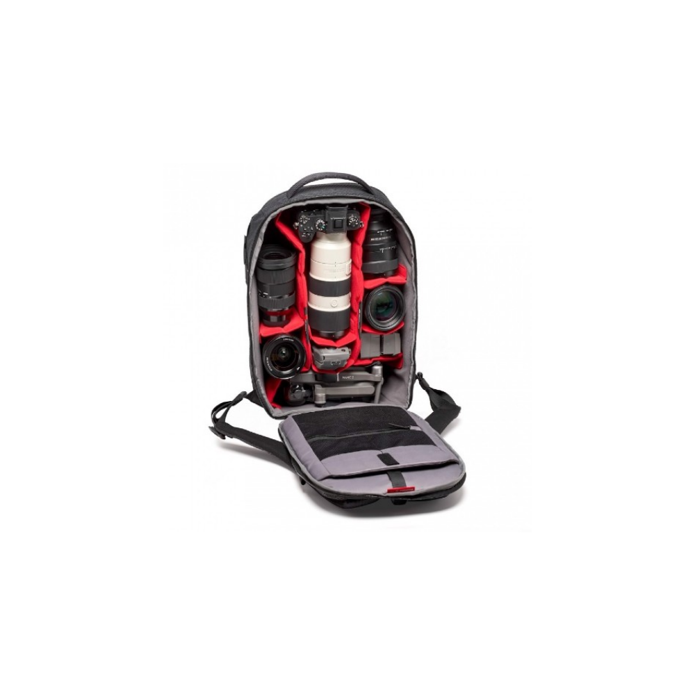An open backpack with camera gear: cameras, lenses, and a drone.