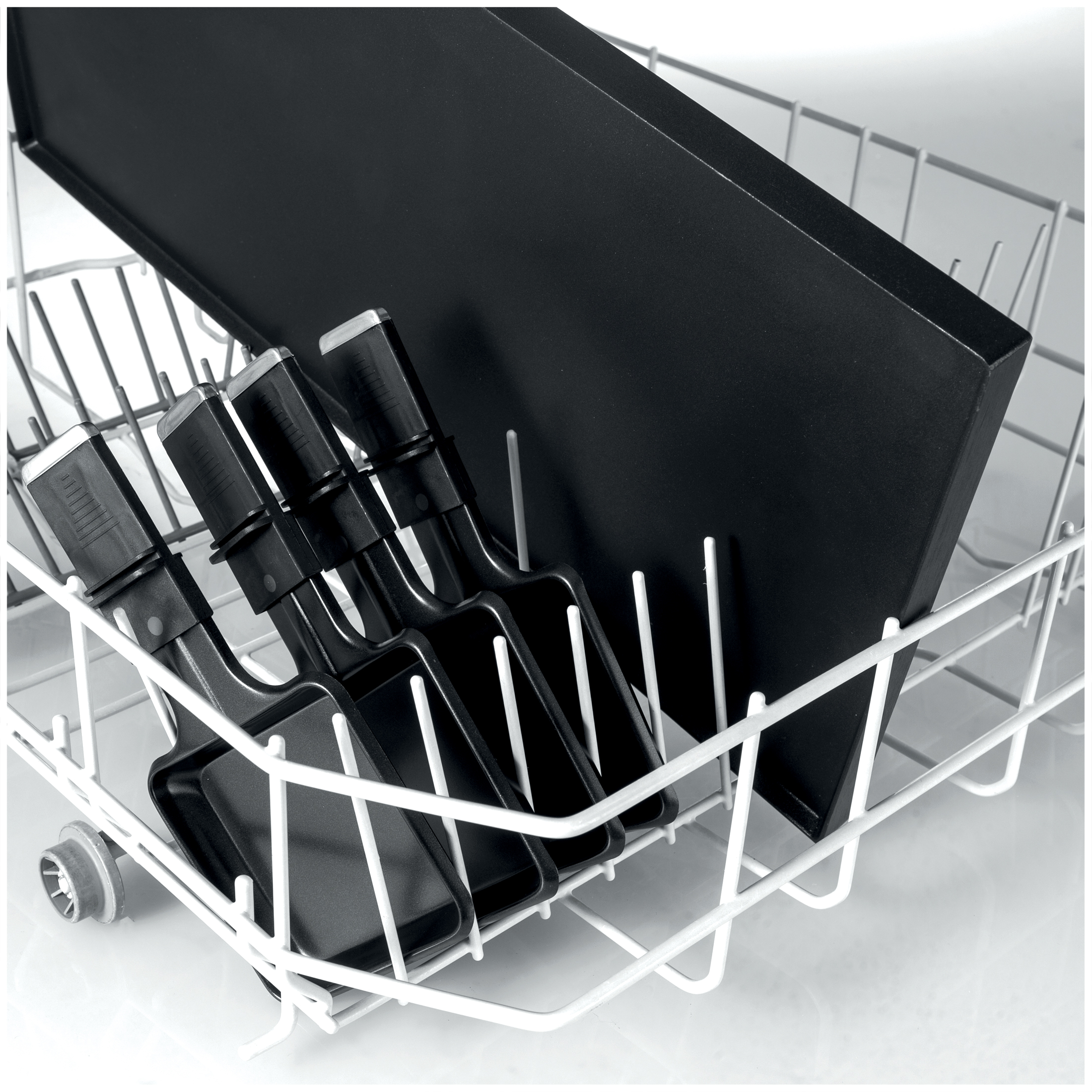 Pans and griddle in a white dishwasher basket.
