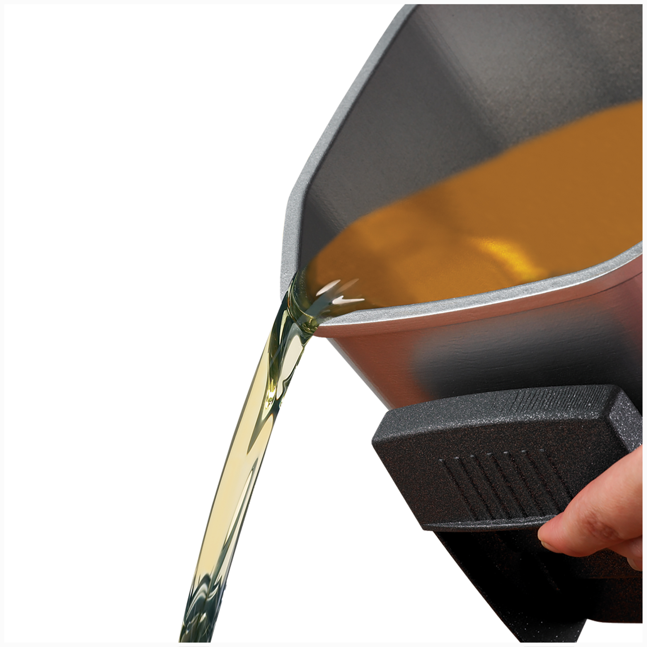 A hand pours yellow liquid from a dark container.