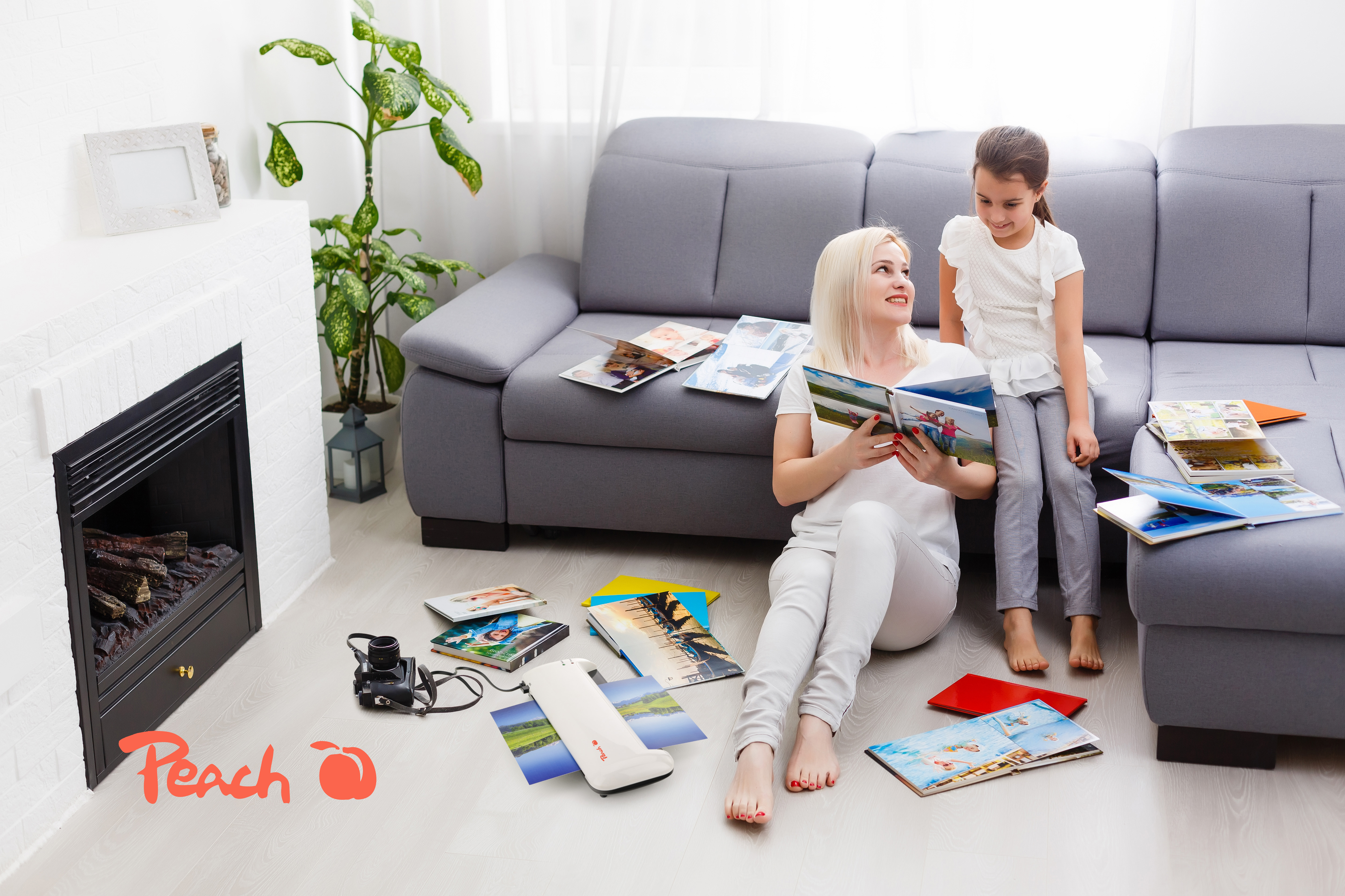 Mère et fille assises par terre regardant des albums photo.