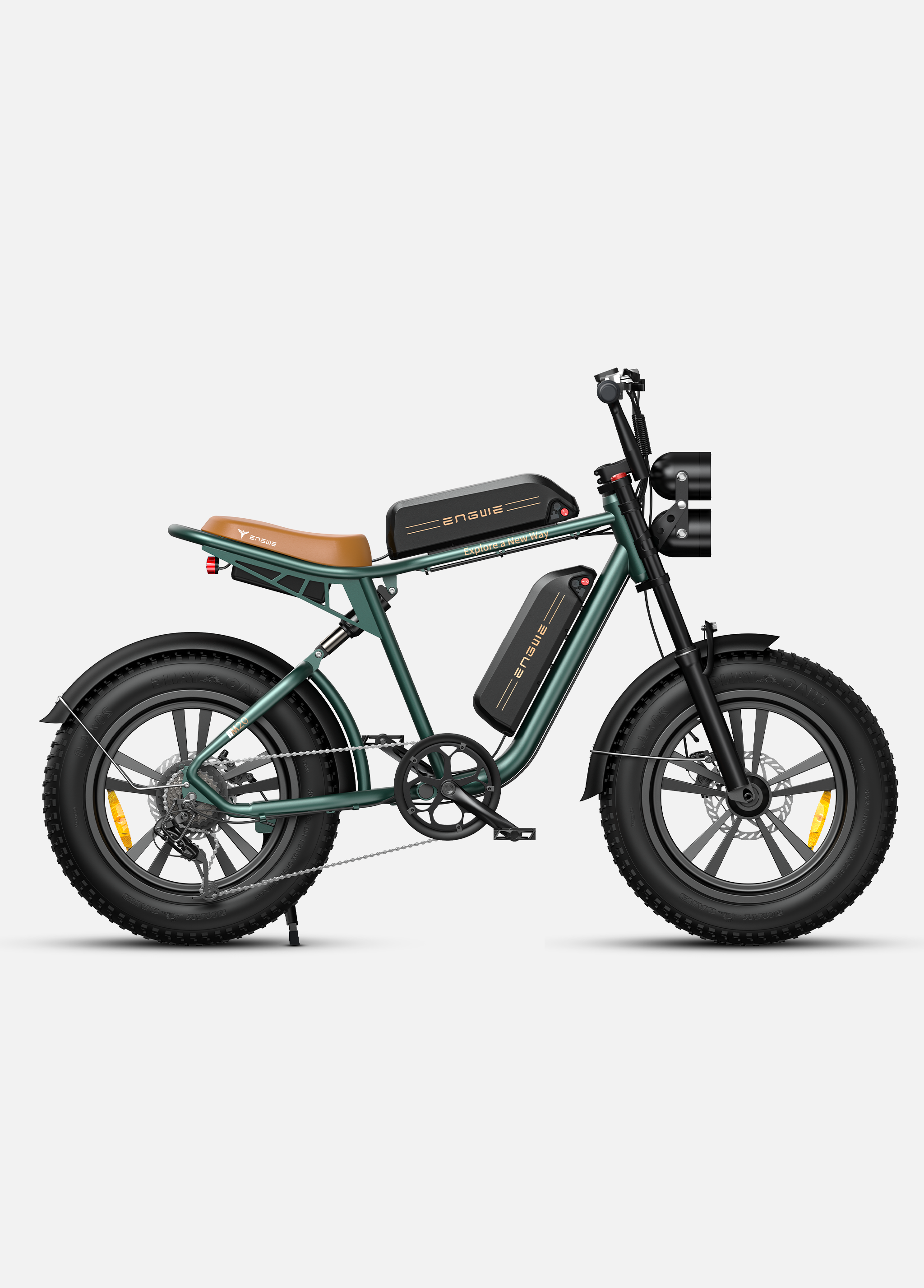 Una e-bike verde scuro con sella marrone e due batterie nere.