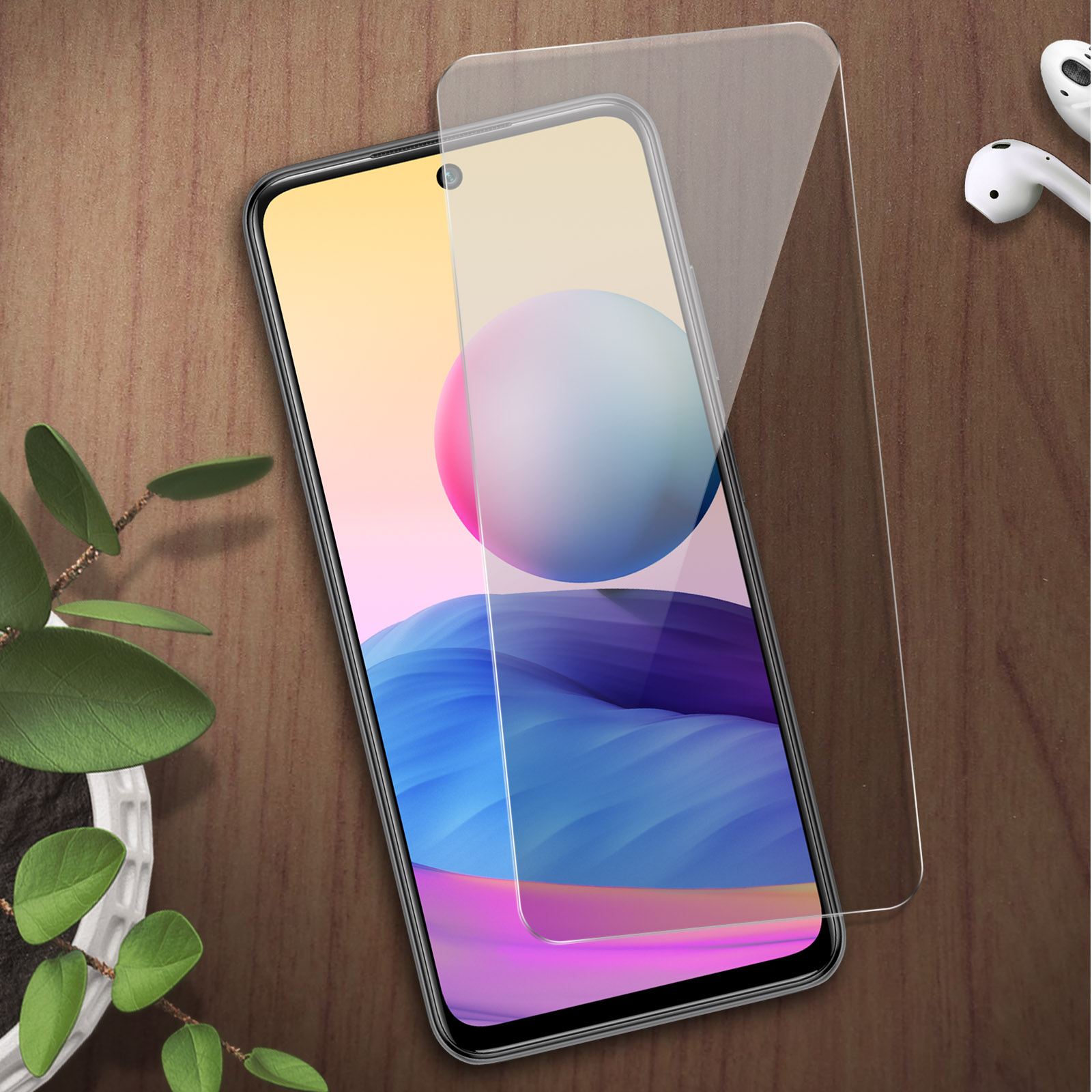 Una pellicola protettiva si trova su uno smartphone con uno sfondo colorato. Una pianta e auricolari nelle vicinanze.