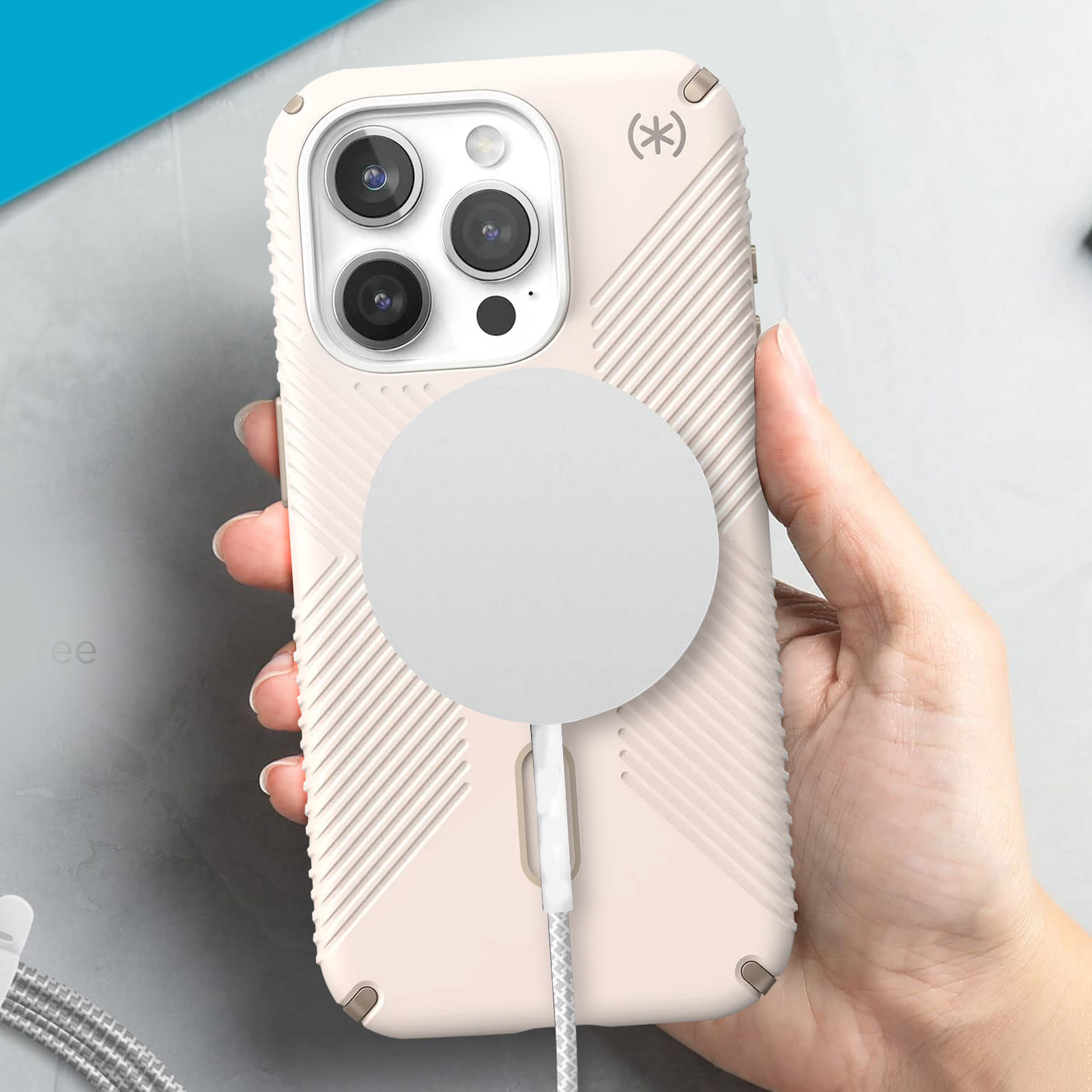 Une main tient un téléphone rose pâle avec un chargeur magnétique blanc.