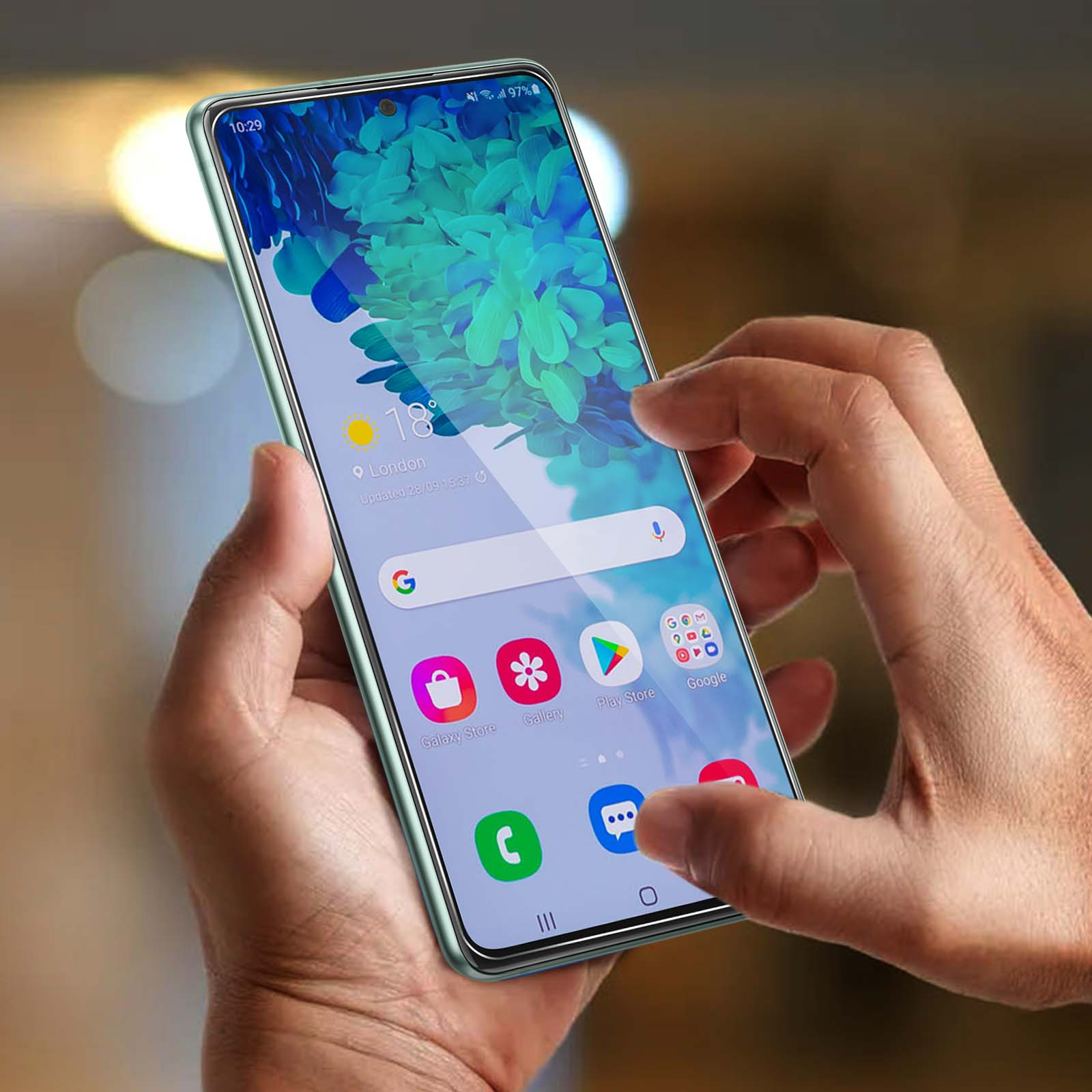 Mani tengono uno smartphone verde chiaro con sfondo blu e informazioni meteo.