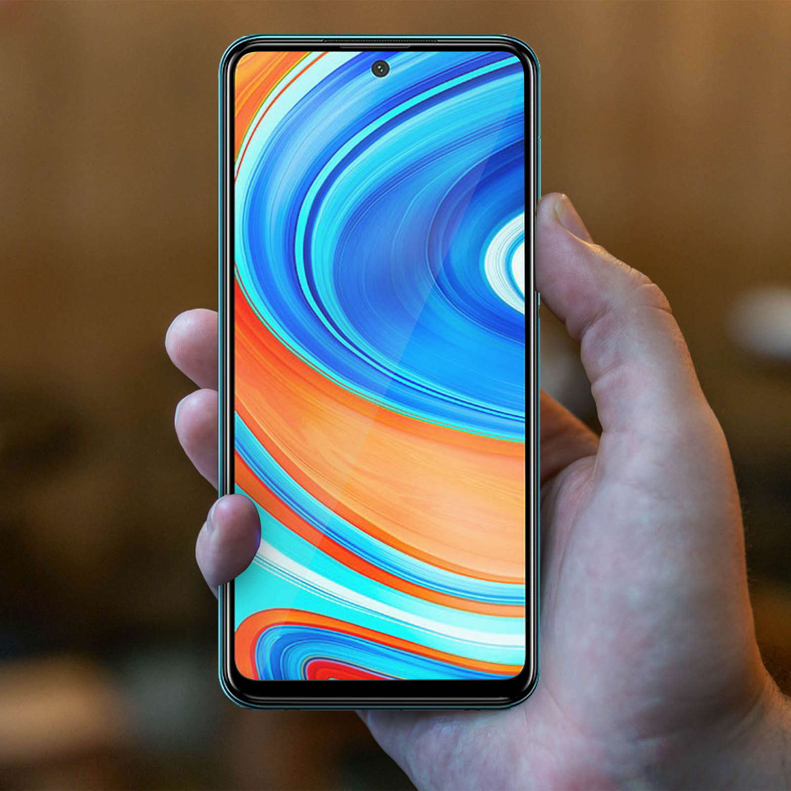 Una mano tiene uno smartphone con uno sfondo colorato.