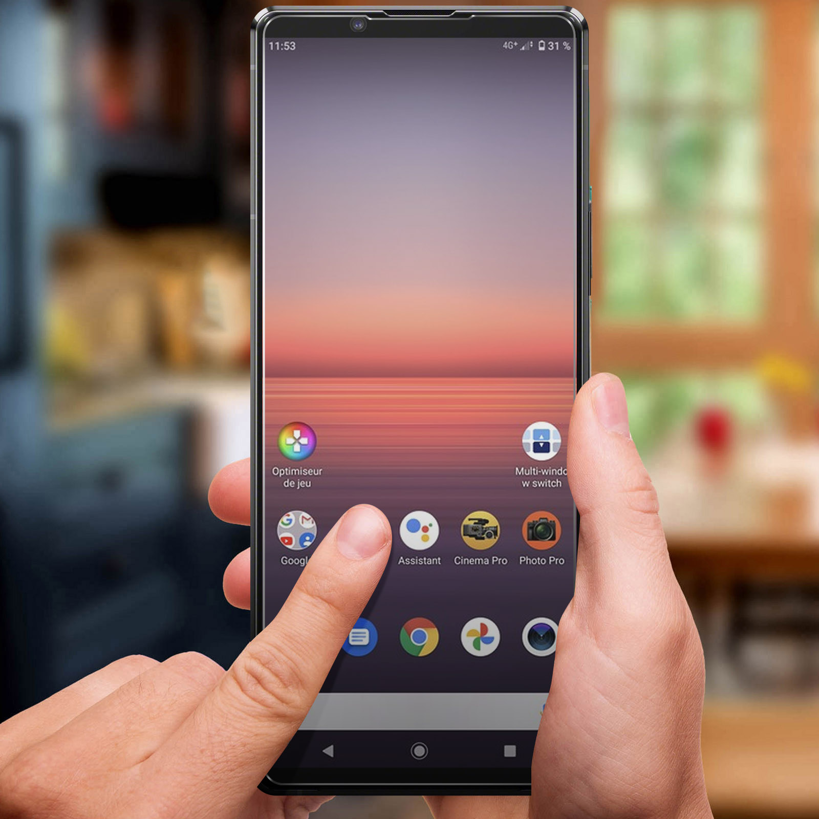 Een hand houdt een smartphone vast met een behang van zonsopgang of zonsondergang.