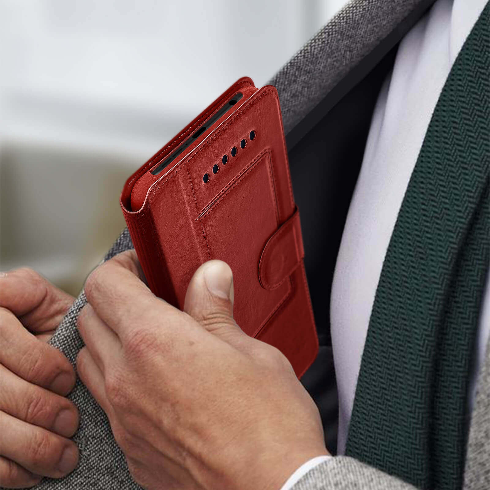 Een rood telefoonhoesje wordt in een zak gestopt. Close-up.