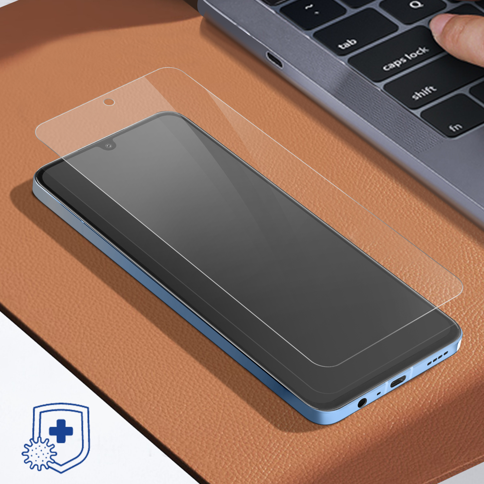 Uno smartphone blu con proteggi schermo giace su pelle marrone accanto a un laptop.