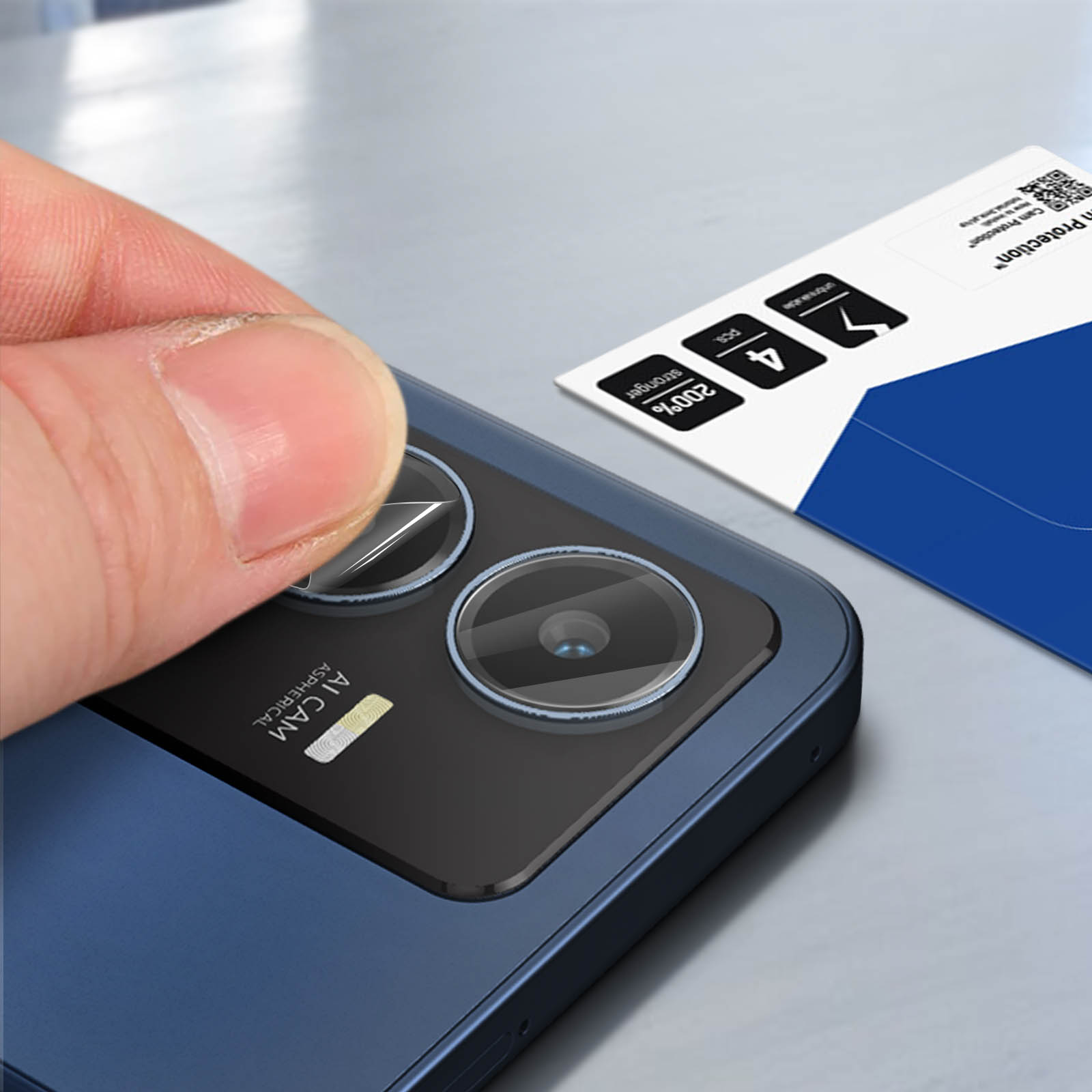 Un dito solleva una protezione per lo schermo dall'obiettivo di uno smartphone blu.