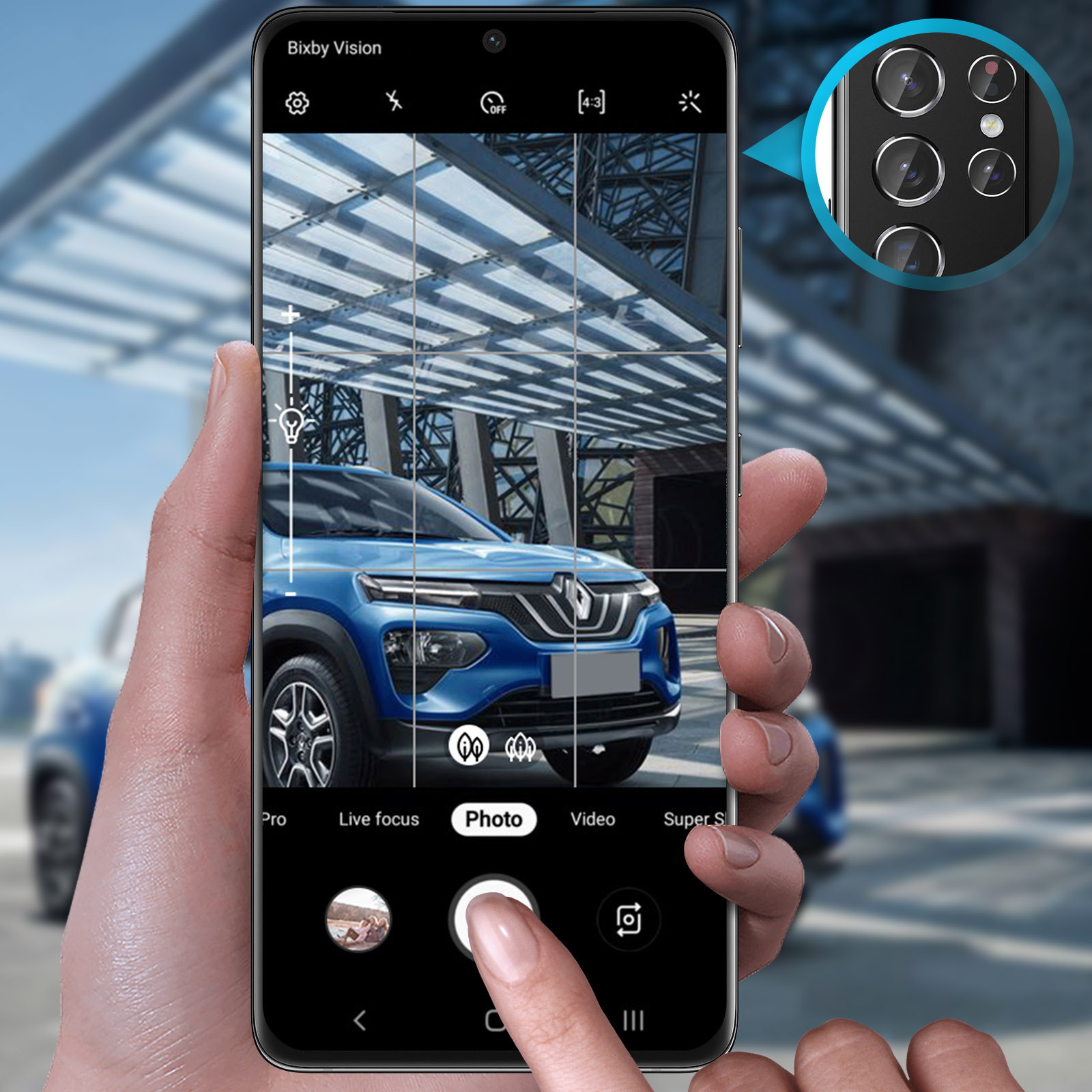 Una mano tiene uno smartphone che mostra la visuale della telecamera di un'auto elettrica blu.