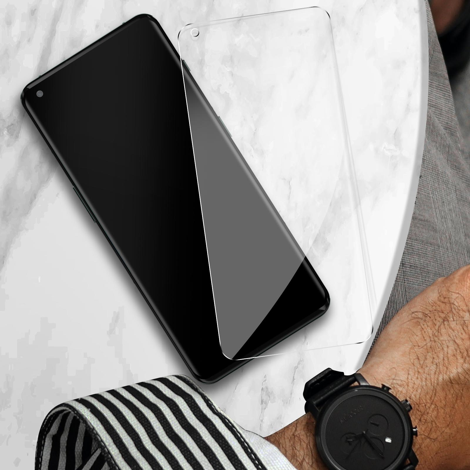 Un smartphone noir à côté d'un protecteur d'écran sur marbre.