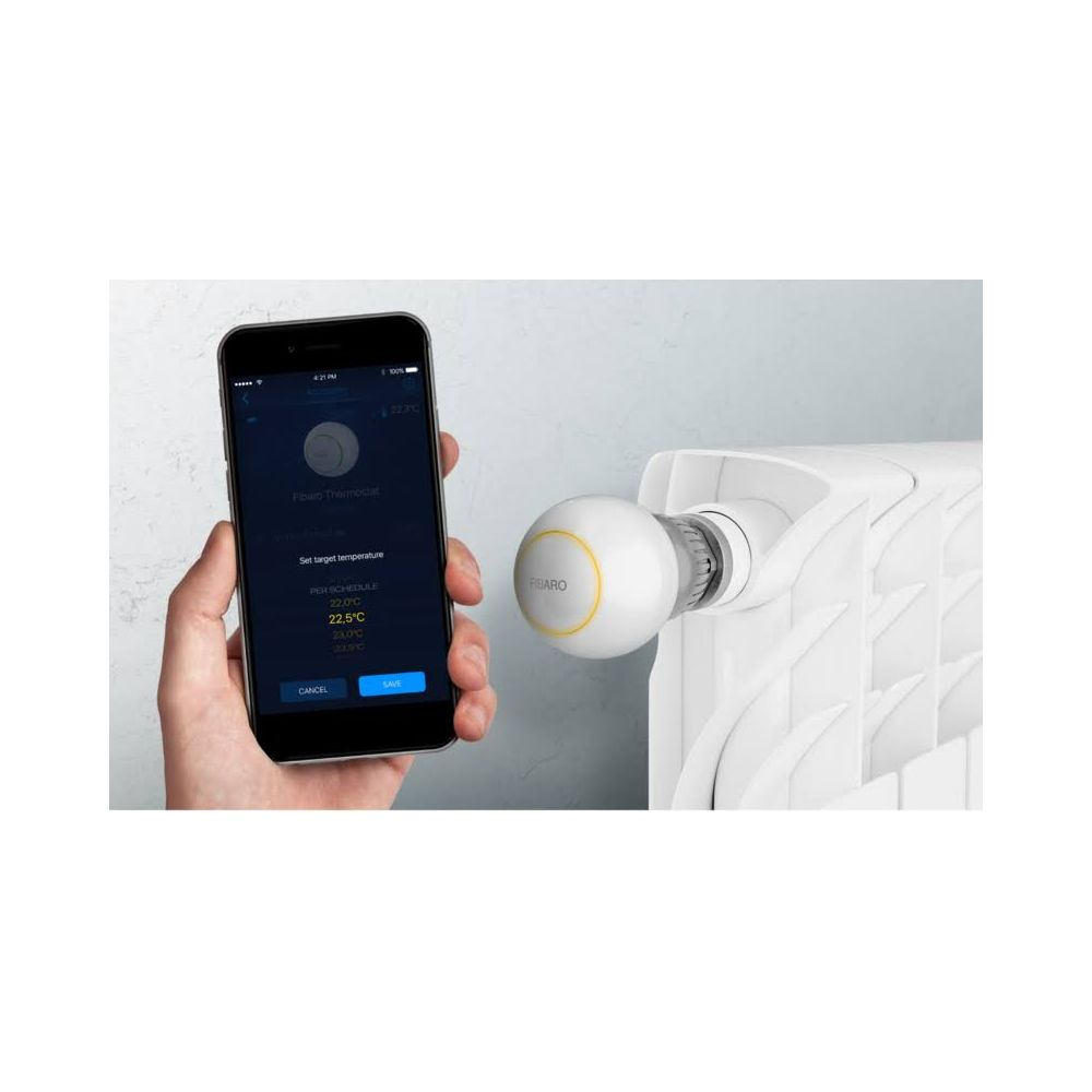 Mano sujetando smartphone con app de termostato de radiador junto a radiador blanco.