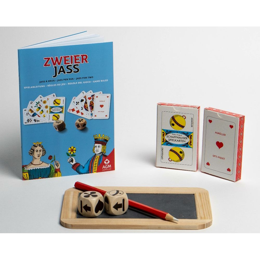 Spielkarten und Würfel für das Kartenspiel Zweier Jass liegen auf einem blauen Buch.