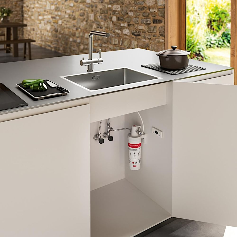 Cucina moderna con lavello, filtro dell'acqua sottostante e una pentola.
