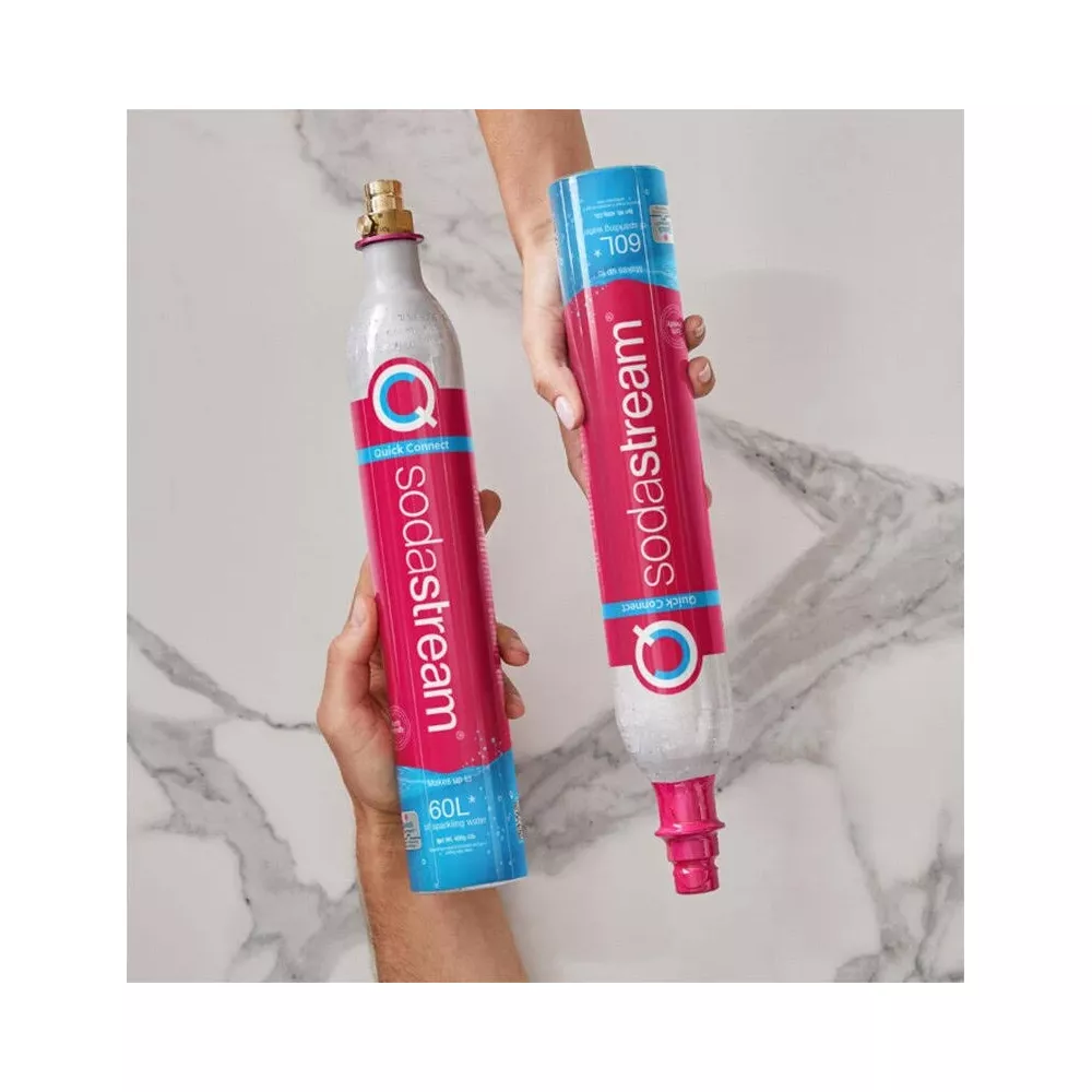Due bombole di CO2 SodaStream tenute da mani. Una è argento, l'altra blu e rosa.