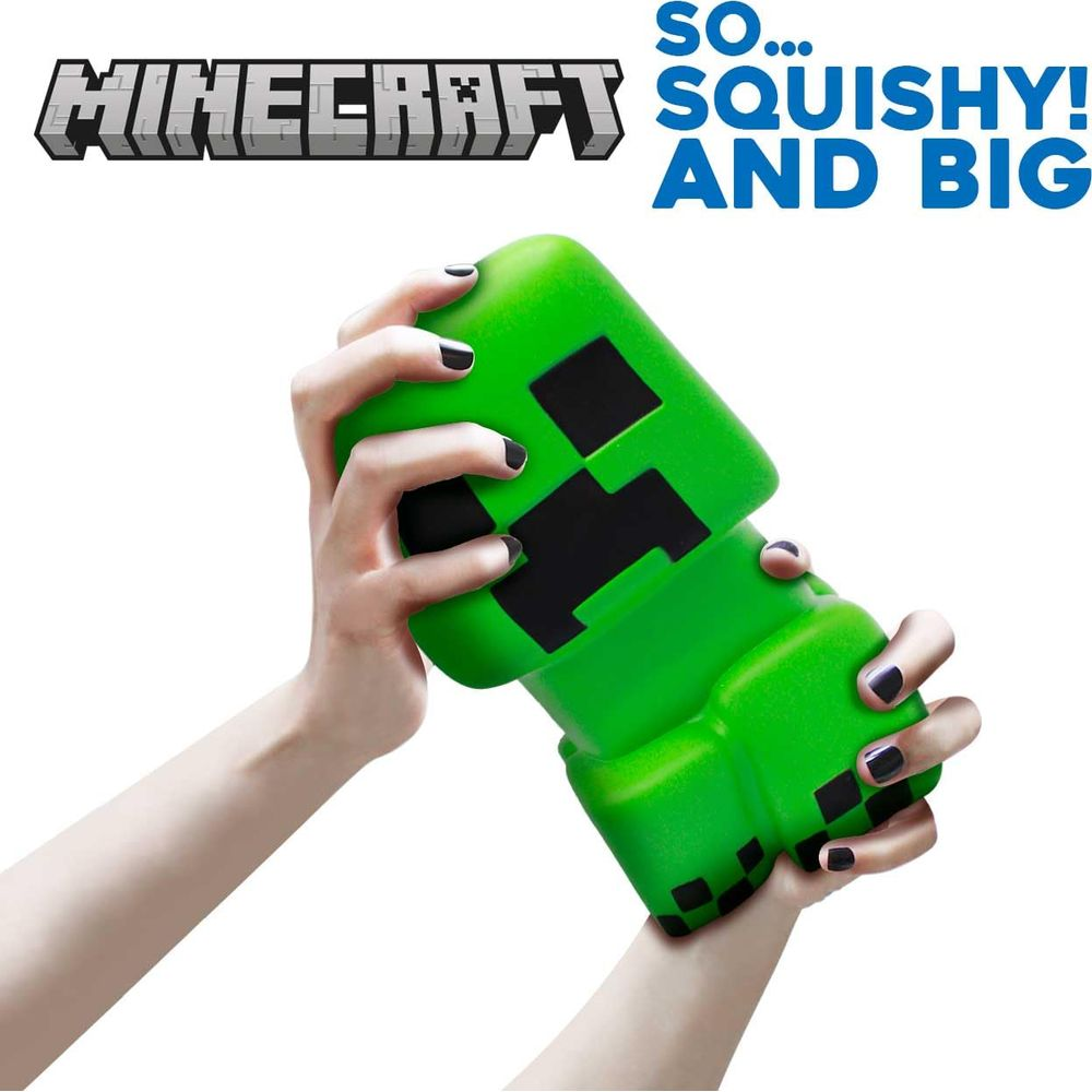 Hände halten eine grüne Minecraft Creeper-Figur mit schwarzen Quadratdetails.