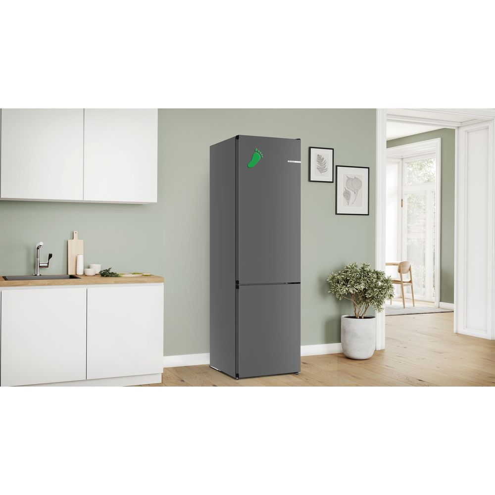 Ein dunkler Kühlschrank mit einem grünen Fußabdruck-Aufkleber in einer Küche.
