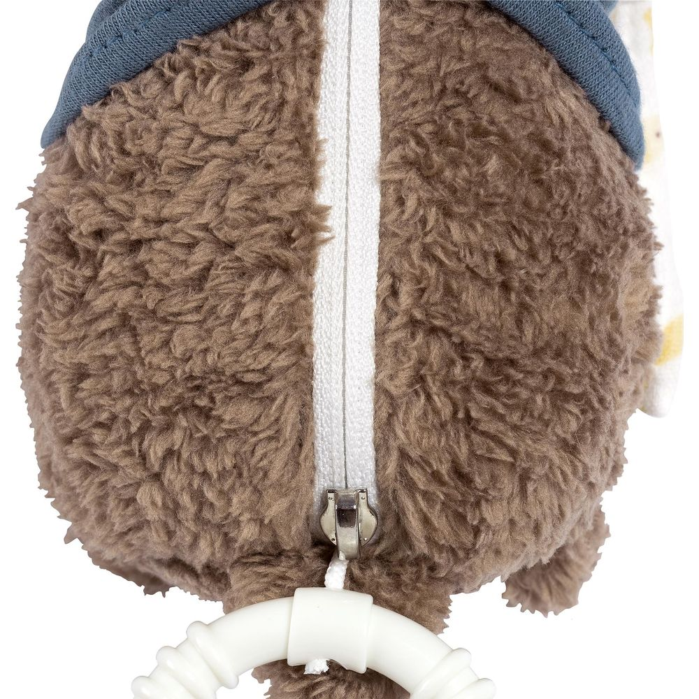 Peluche marrone con cerniera, cappello blu e anello giocattolo bianco.