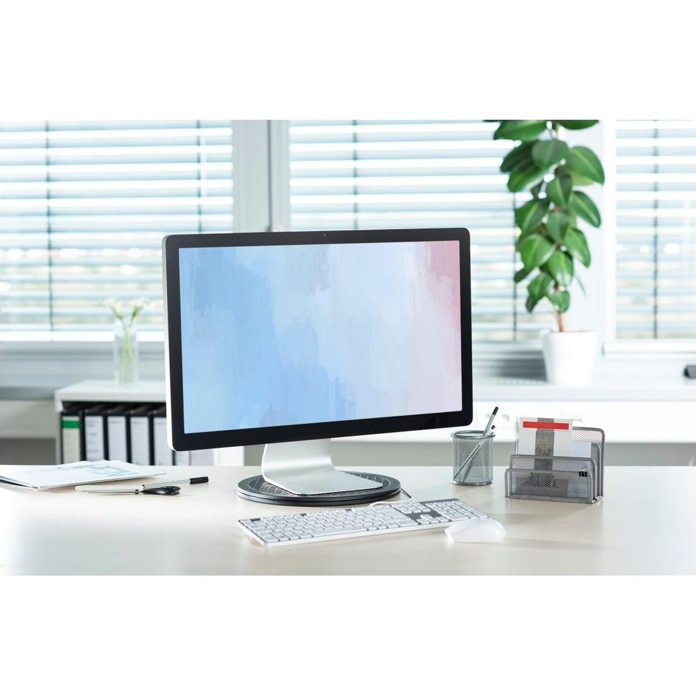 Una scrivania con monitor, tastiera, mouse e cancelleria.