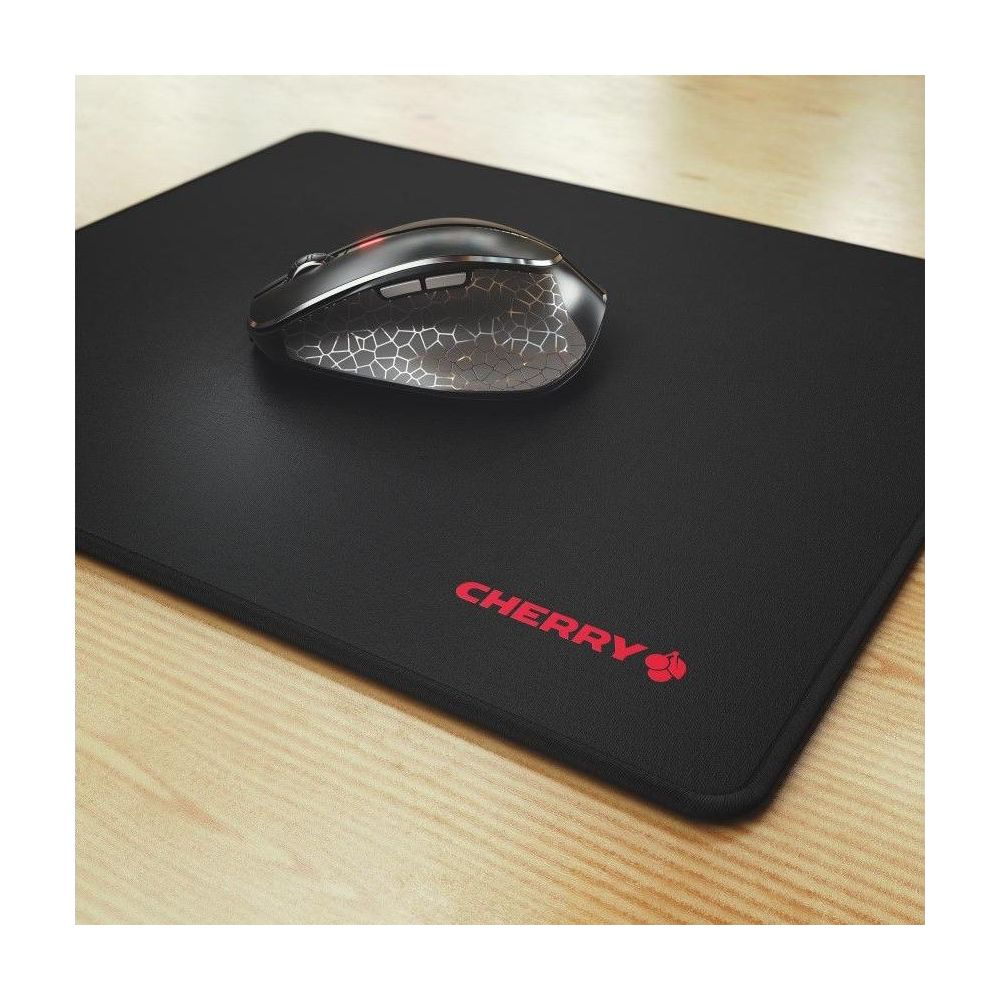 Czarna mysz na czarnej podkładce z czerwonym logo Cherry, na drewnianym biurku.