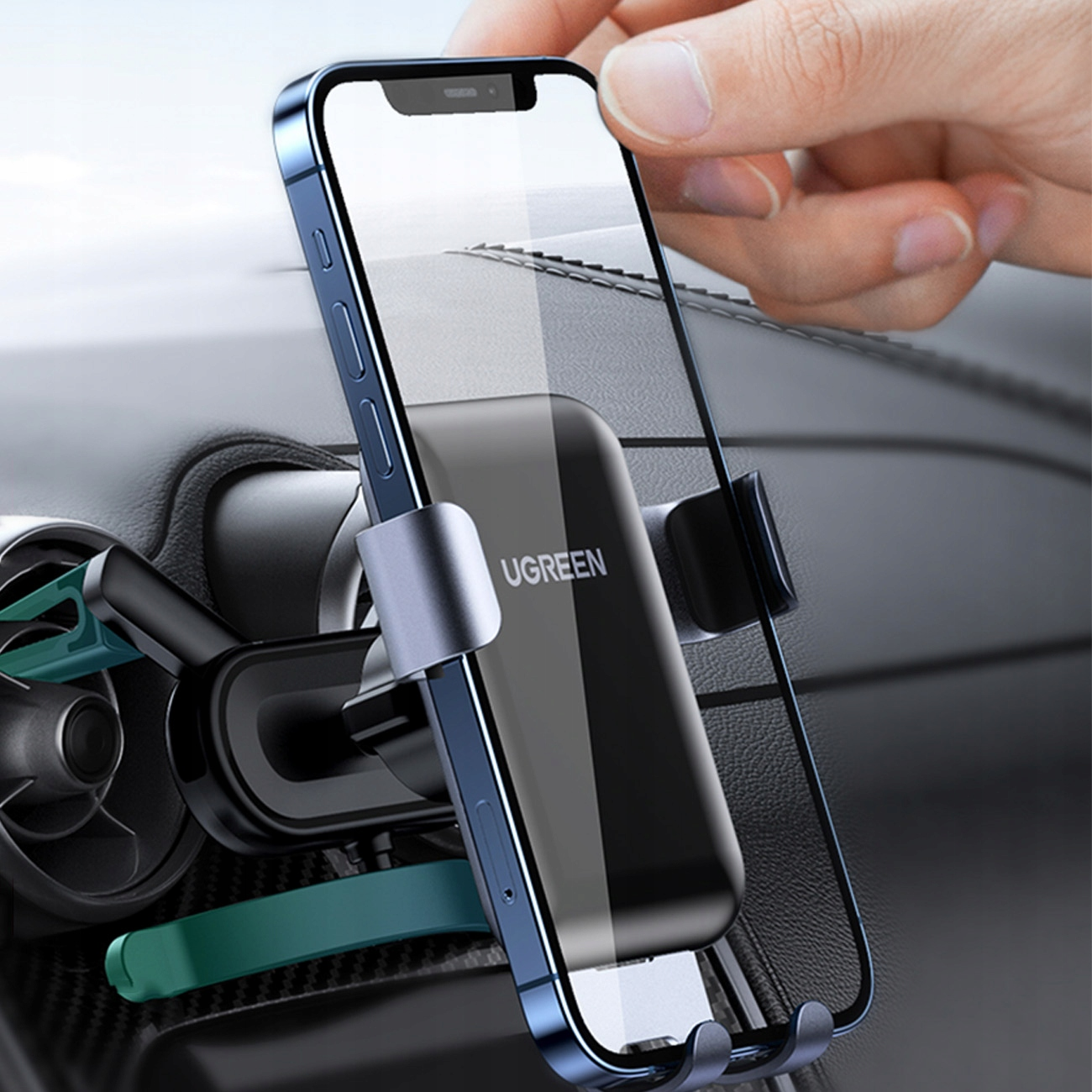 Dłoń umieszcza smartfon w uchwycie samochodowym UGREEN na desce rozdzielczej.
