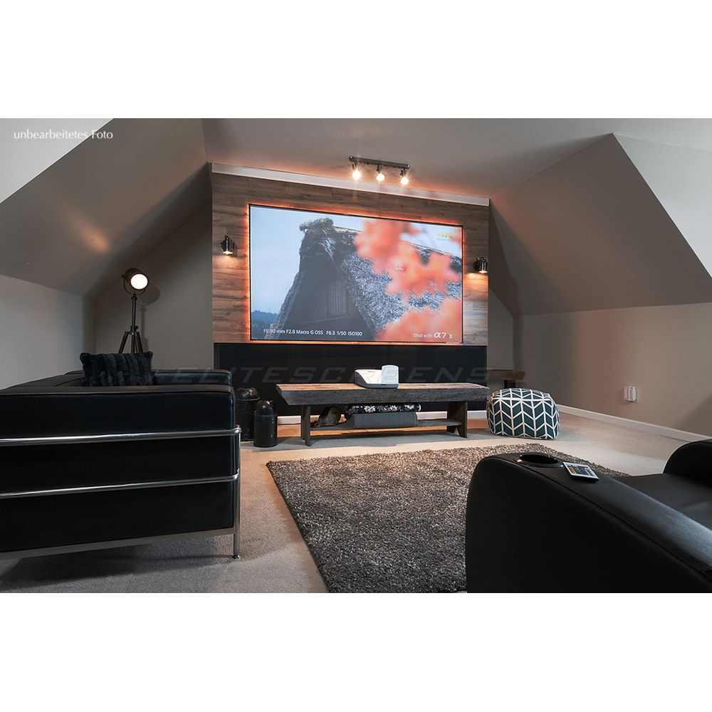 Ein modernes Heimkino mit Leinwand, schwarzen Sofas und einem Holztisch.