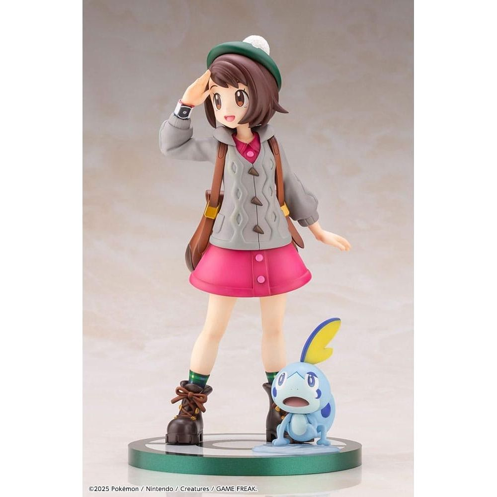 Una figura di ragazza in rosa e grigio, con borsa e un Pokémon blu.