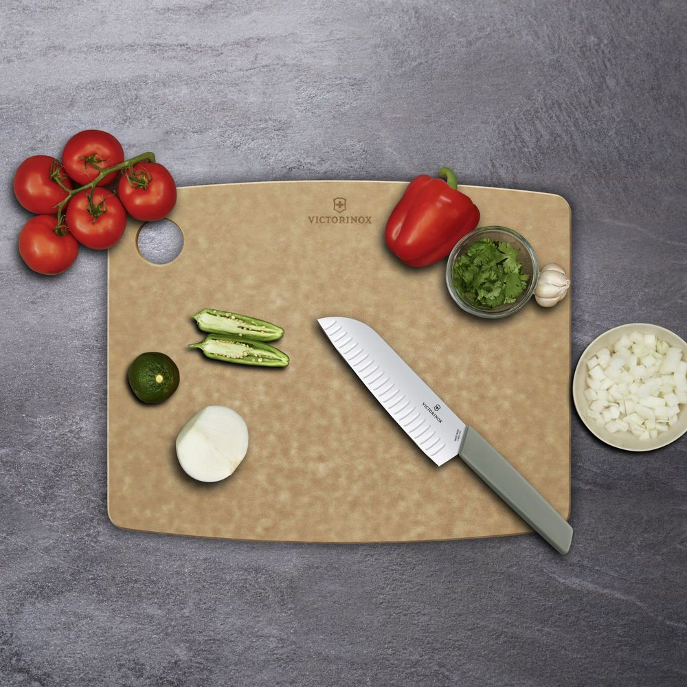 Schneidebrett mit Tomaten, Jalapenos, Zwiebeln, Paprika, Knoblauch, Koriander und Messer.