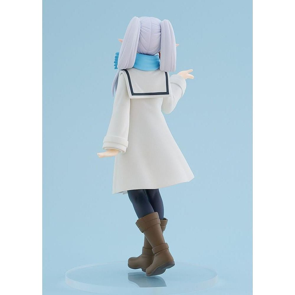 Una figura con pelo morado, abrigo blanco, bufanda azul y botas marrones se alza sobre fondo azul.