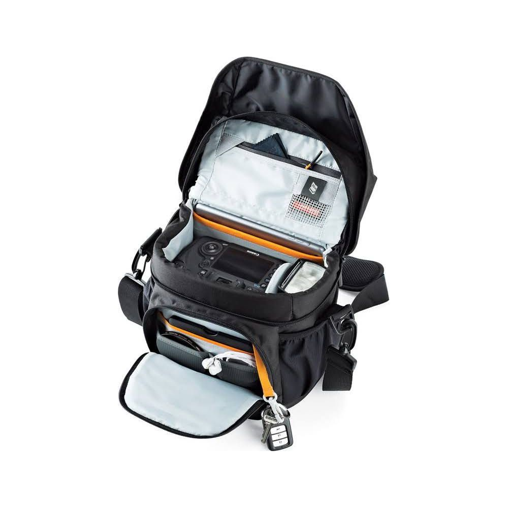 Offene schwarze Kameratasche mit Kamera, Zubehör und Schlüsseln.
