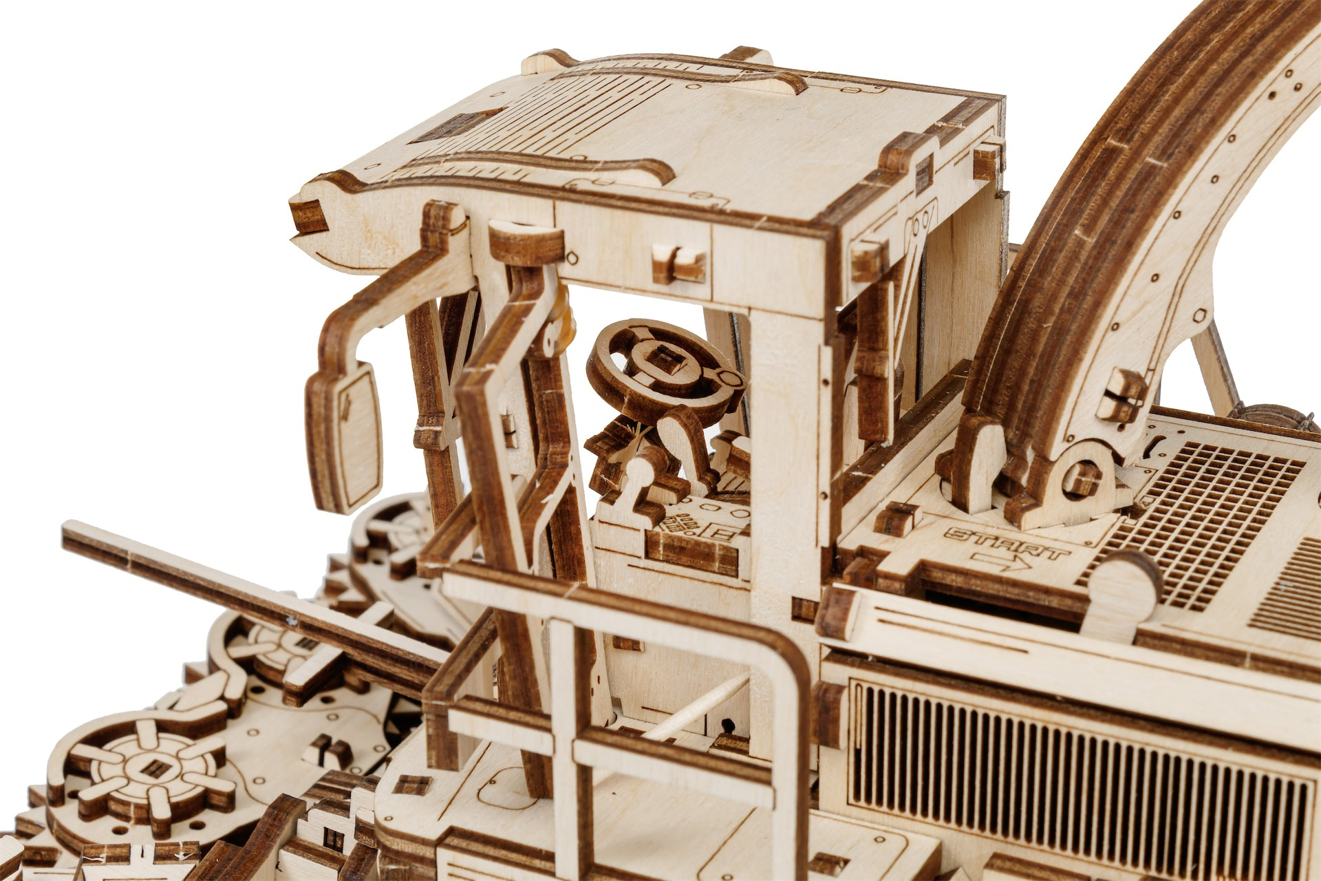 Ein detailliertes Holzmodell eines Traktors mit Kabine, Lenkrad und Aufbau.