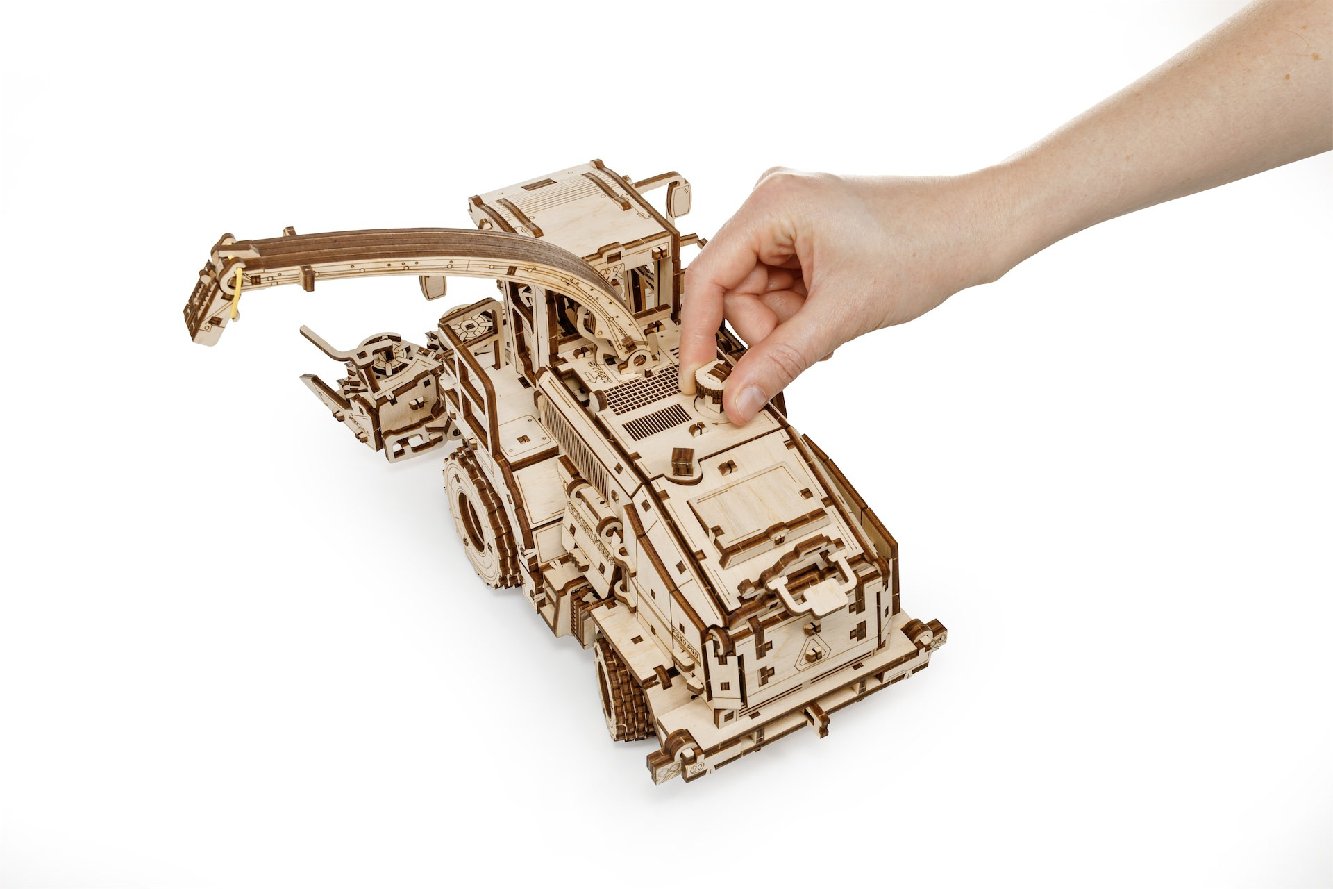 Ein Holzlokomotivmodell mit ausfahrbarem Arm, das von einer Hand bedient wird.