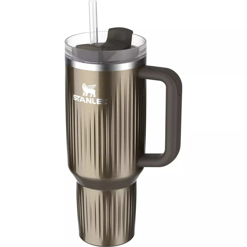 Un vaso Stanley alto, de color dorado metálico, con asa y pajita gris oscuro.