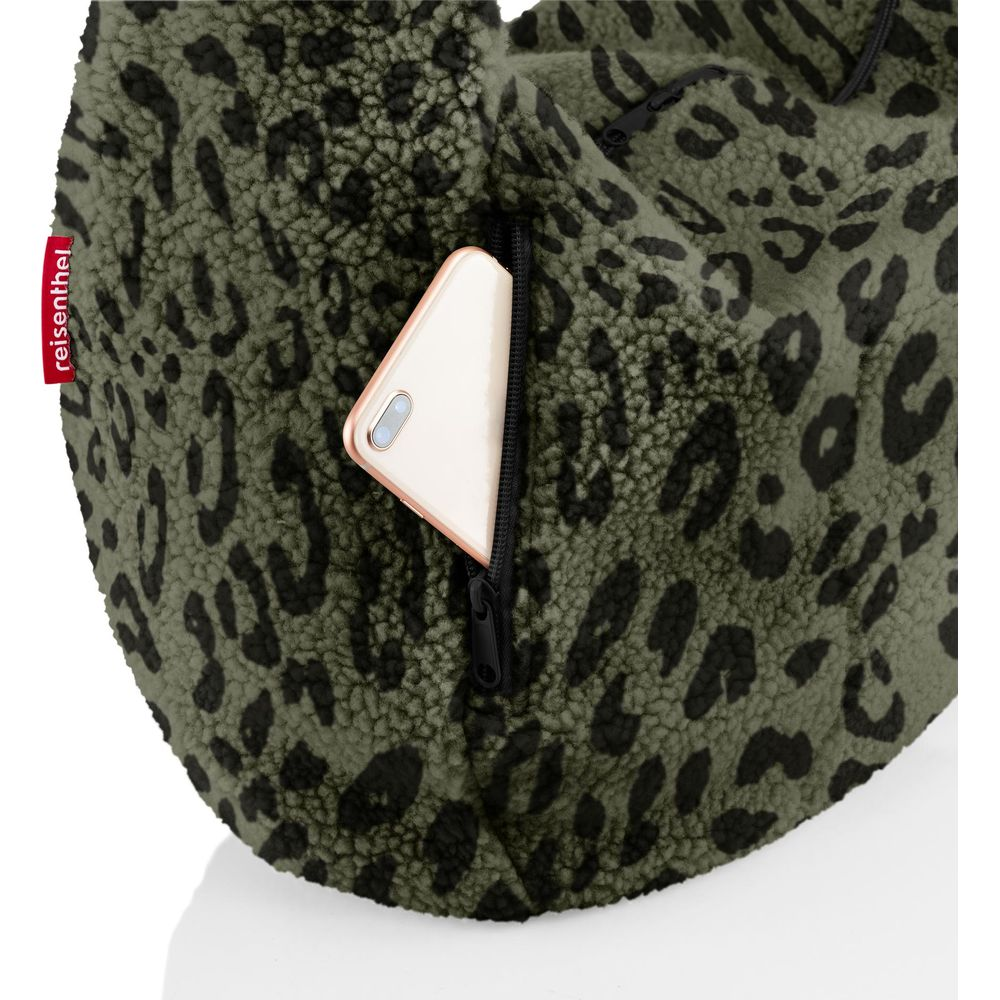 Grüne Tasche mit Leopardenmuster und einer Handytasche, aus der ein Handy ragt.