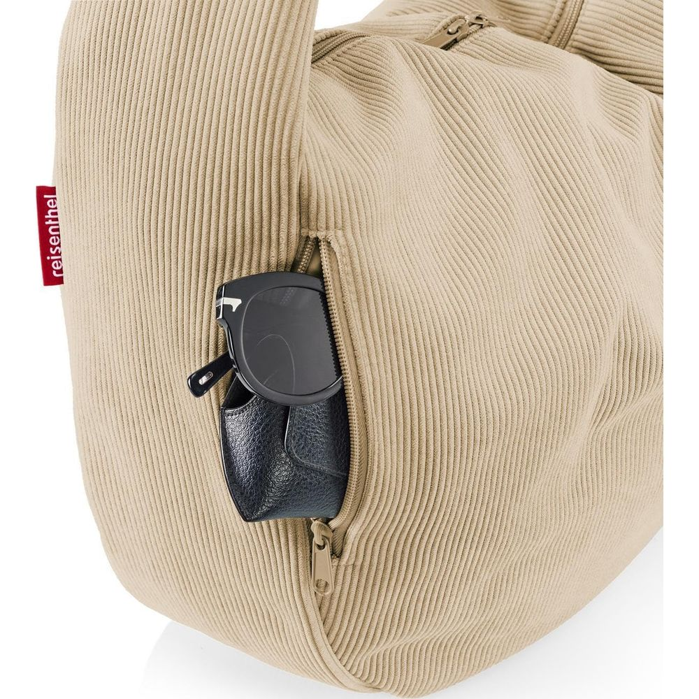 Braune Tasche mit Reißverschlusstasche, darin Sonnenbrille und Etui.