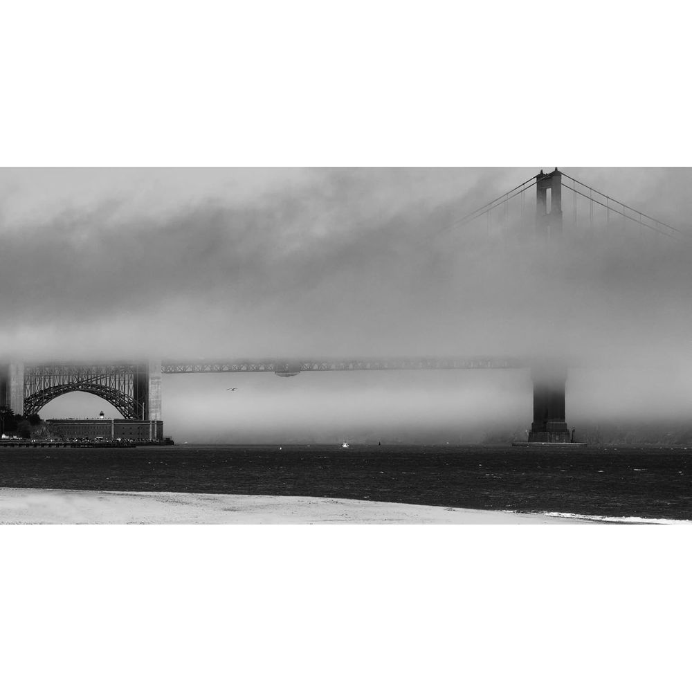 Die Golden Gate Bridge im Nebel, mit Booten auf dem Wasser.