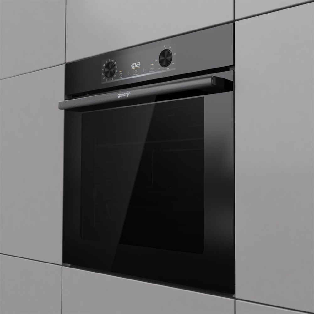 Ein moderner schwarzer Gorenje-Ofen mit Glastür und Digitalanzeige, in grauen Schränken.