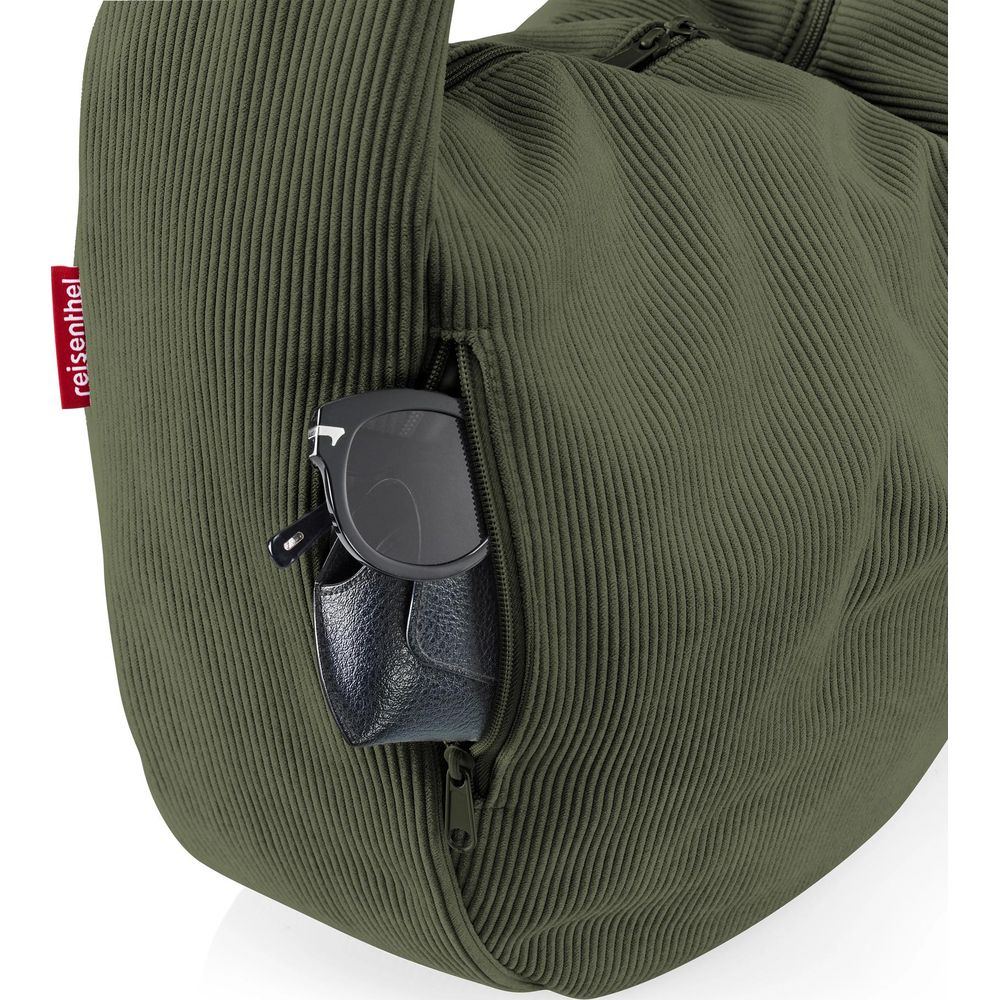 Grüne Tasche mit Reißverschlussfach, darin Sonnenbrille und Etui.