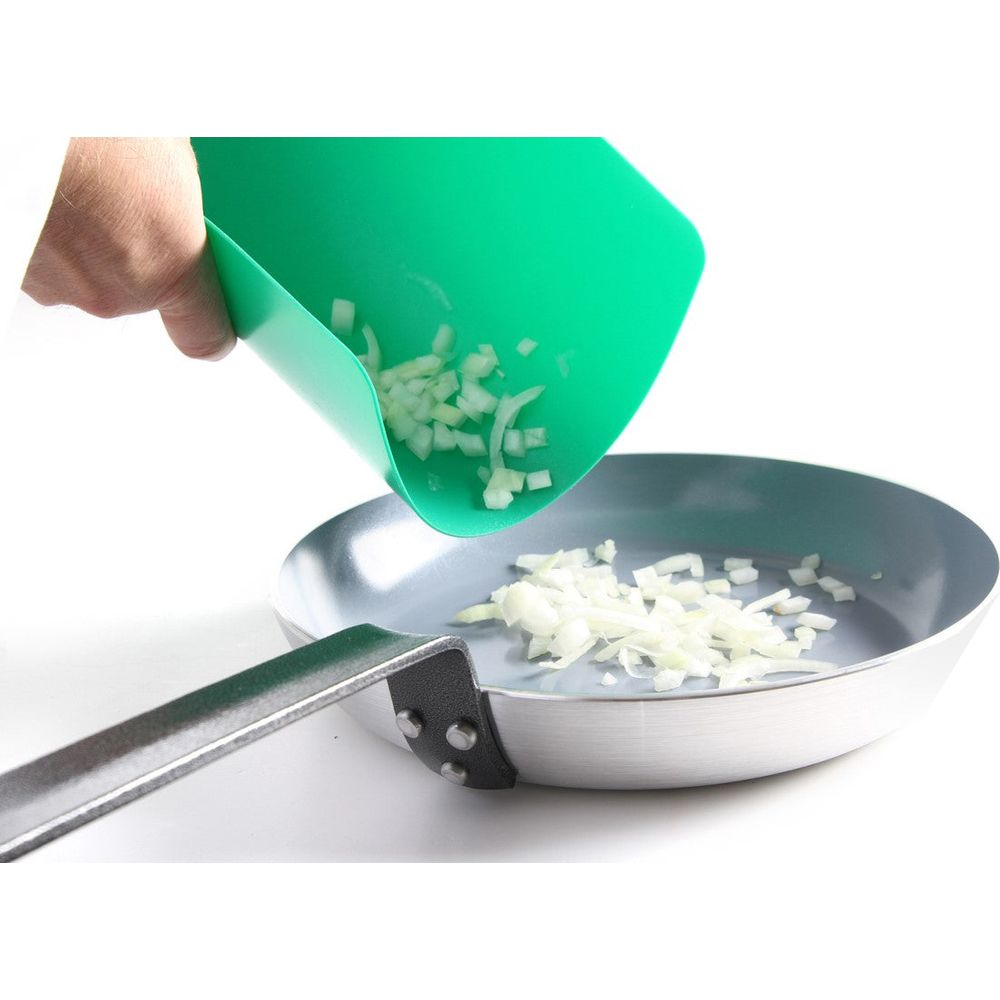 Cipolle tritate cadono da un tappetino verde in una padella.