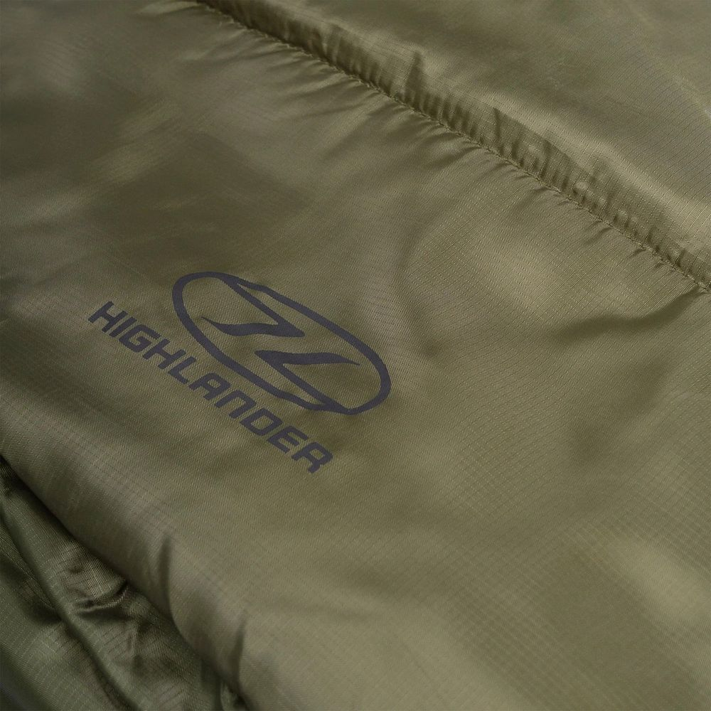 Grüner Stoff mit dunklem Highlander-Logo und Nähten.