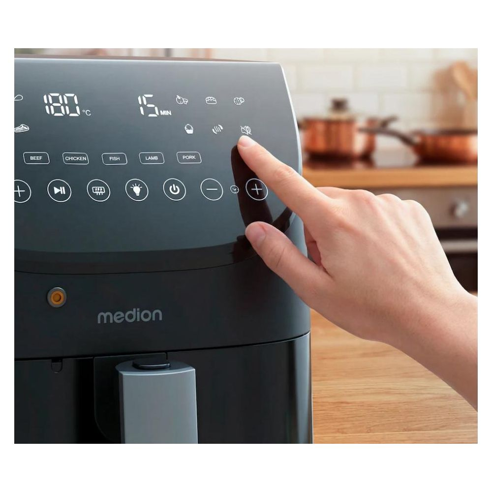 Een hand drukt op het bedieningspaneel van een zwarte airfryer met digitale instellingen.