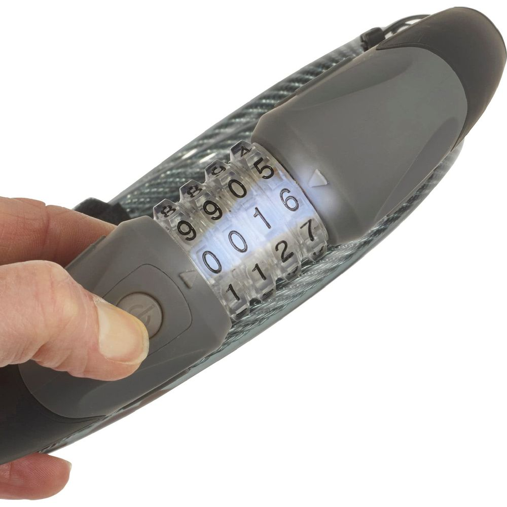 Una mano presiona un botón gris en un candado de combinación con diales numéricos iluminados.