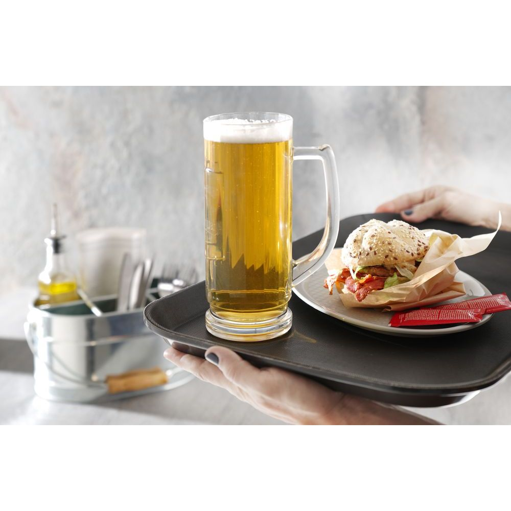 Una persona tiene un vassoio con una birra in boccale e un hamburger.
