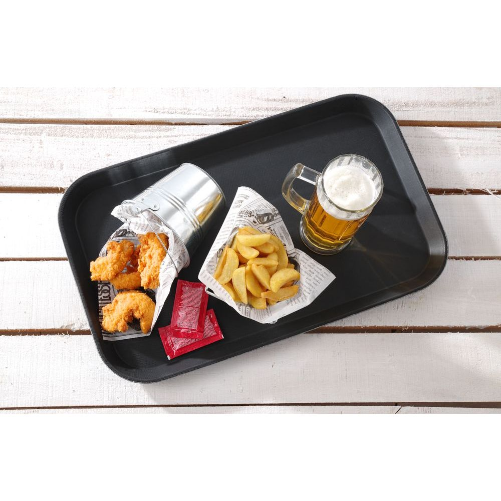 Un vassoio con pollo fritto, patatine fritte e una birra. Diversi pacchetti di salsa rossa.