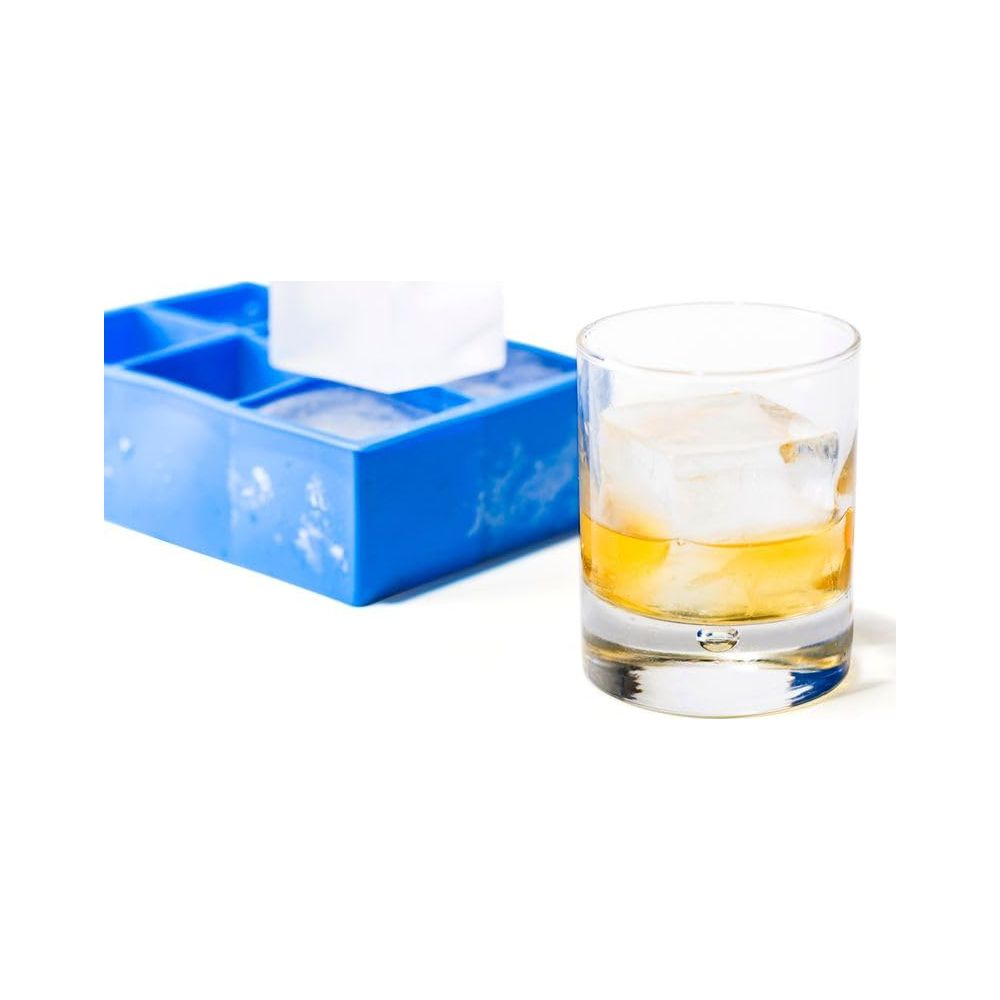 Una vaschetta per cubetti di ghiaccio blu accanto a un bicchiere di liquido ambrato con un cubetto di ghiaccio.