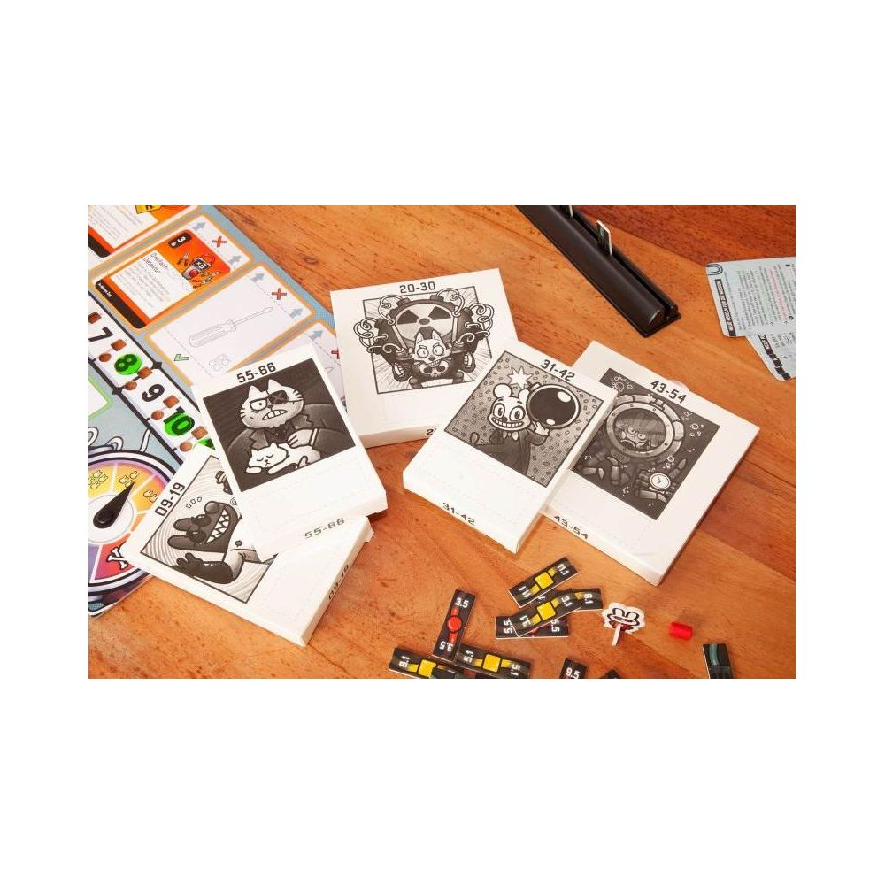 Componenti di gioco da tavolo su un tavolo di legno, incluse carte con cartoni animati e pedine.
